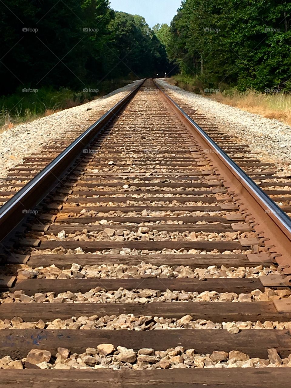 Railroad tracks on railroad bed leading to town