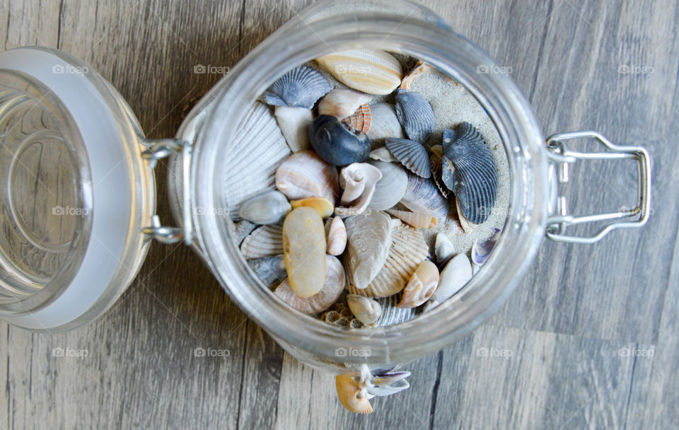 Glass jar full of sea shells and sand