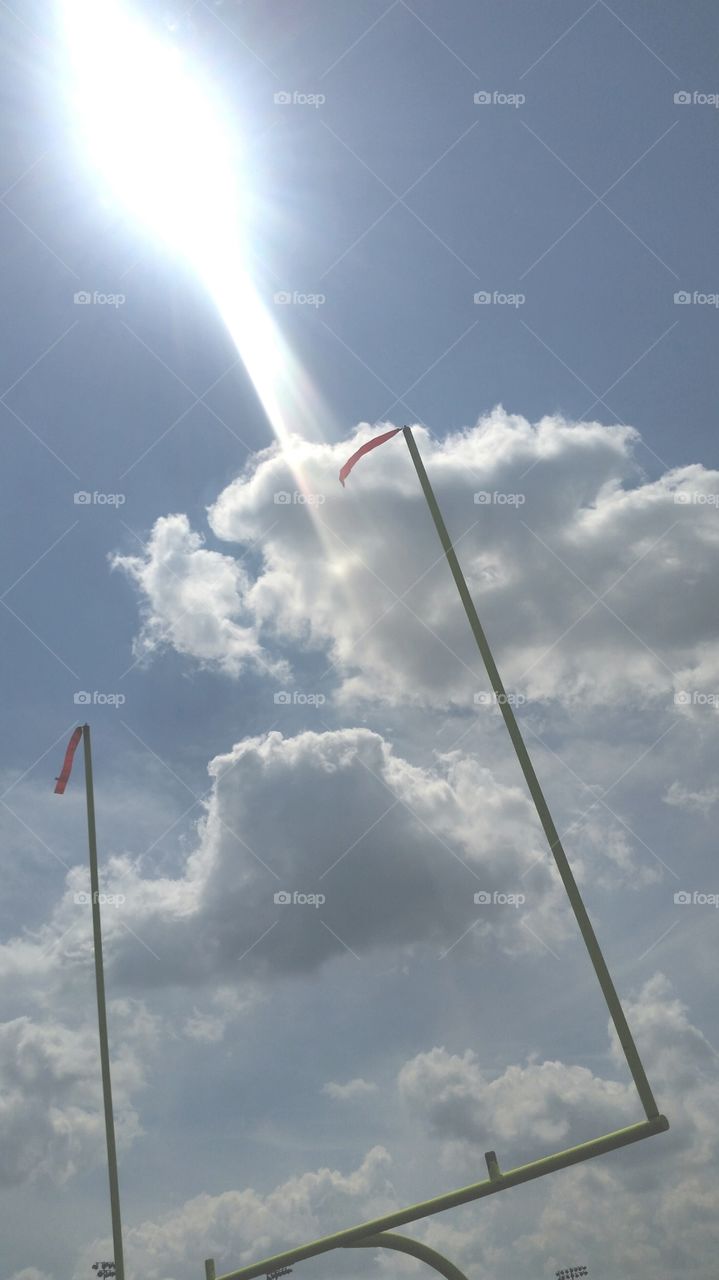 sun streak behind the goal posts with clouds
