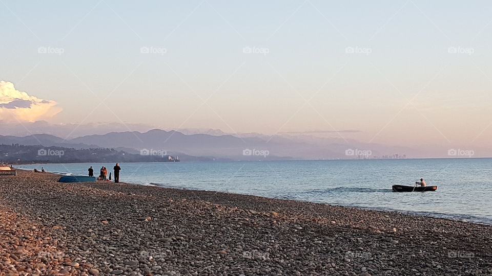 deserted beach and fishermen at sunset