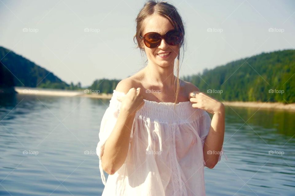 Woman in white dress with lake in the background