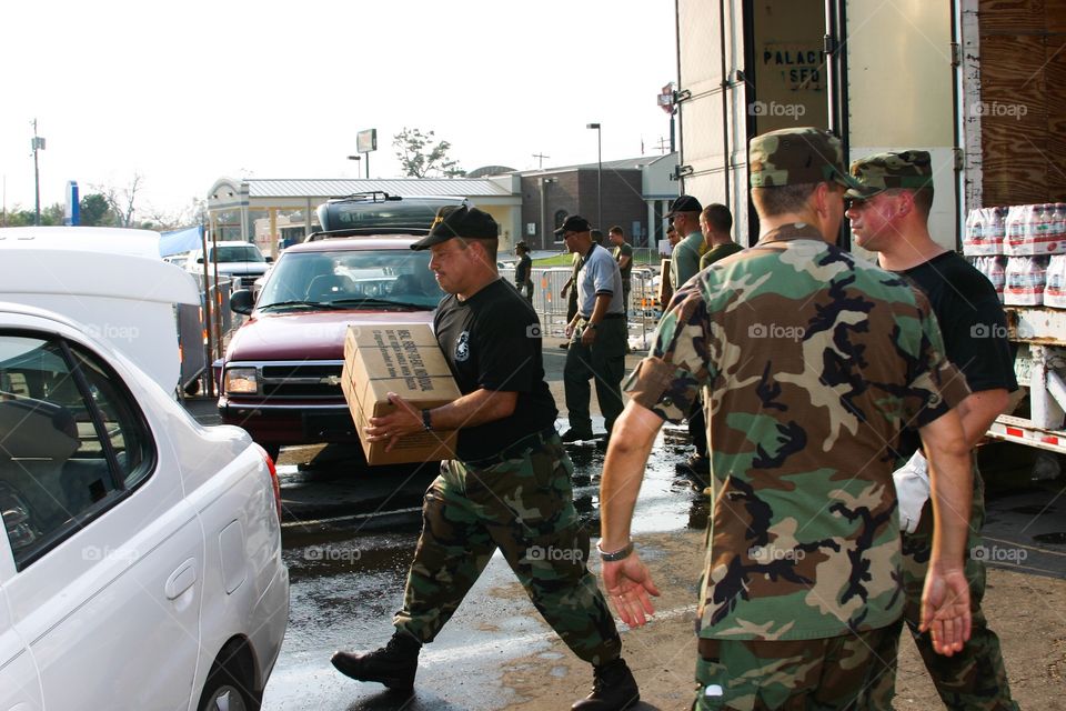 Air Force Sergeant loads emergency supplies into civilian car 