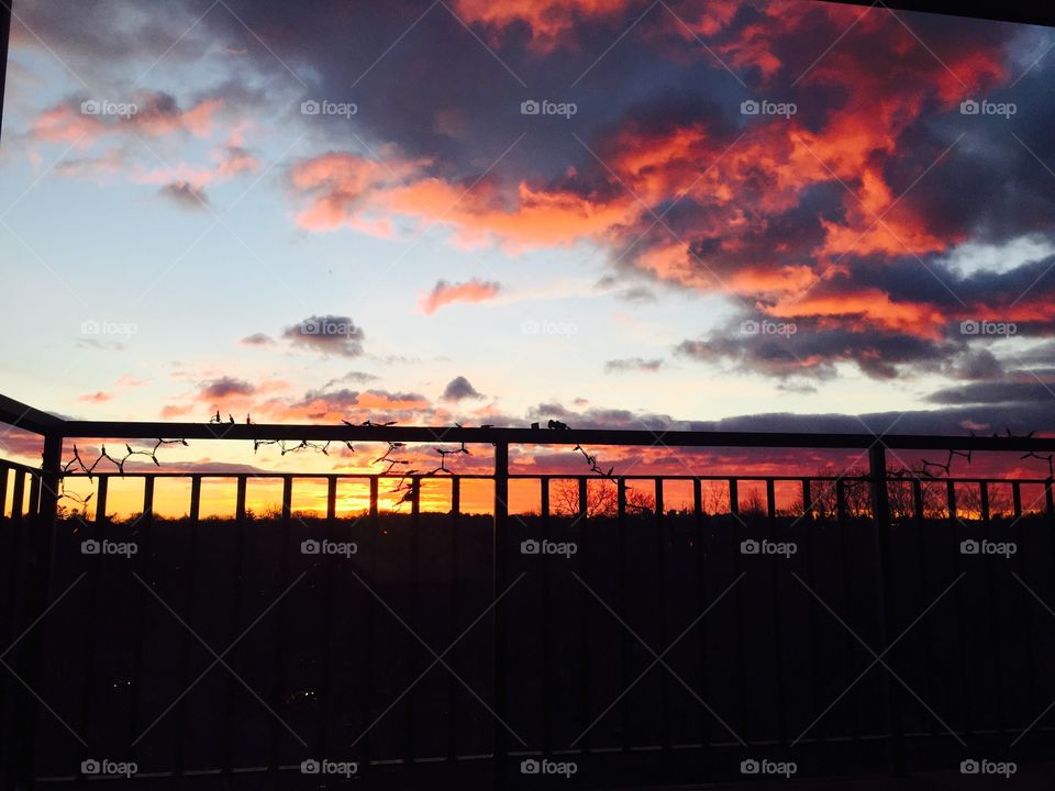 Sun raise with on a balcony  with city view and tree line background. Beautify bright orange color 