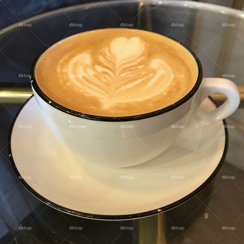 Dark rimmed coffee cup and saucer with latte art 