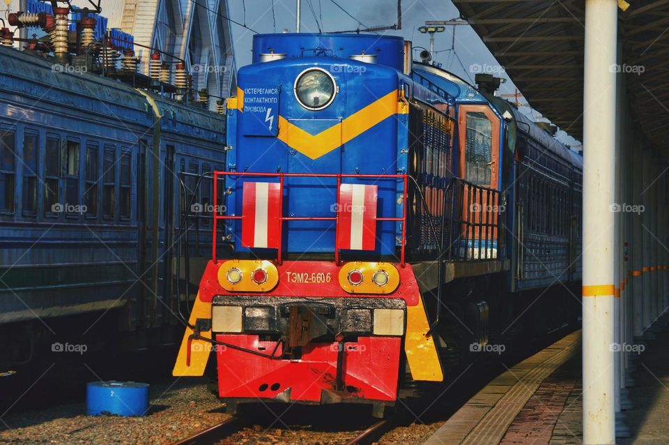 blue tractor locomotive on diesel traction. old rolling stock with bright colors.