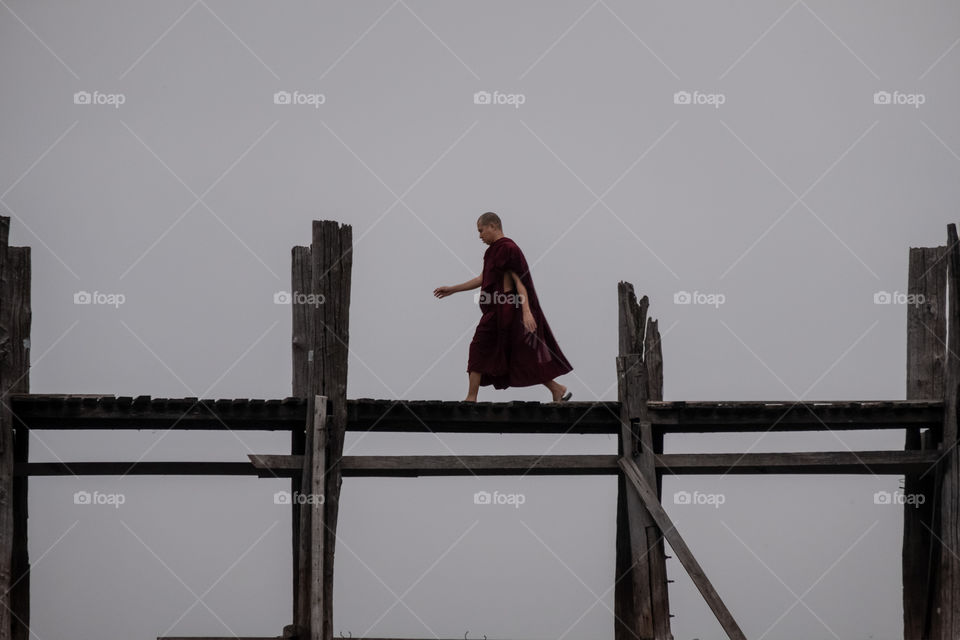 Myanmar monk walk on the longest Uben wooden bridge in Mandalay
