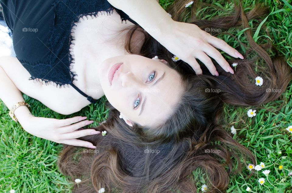 Portrait of a woman brunette on a background of daisies