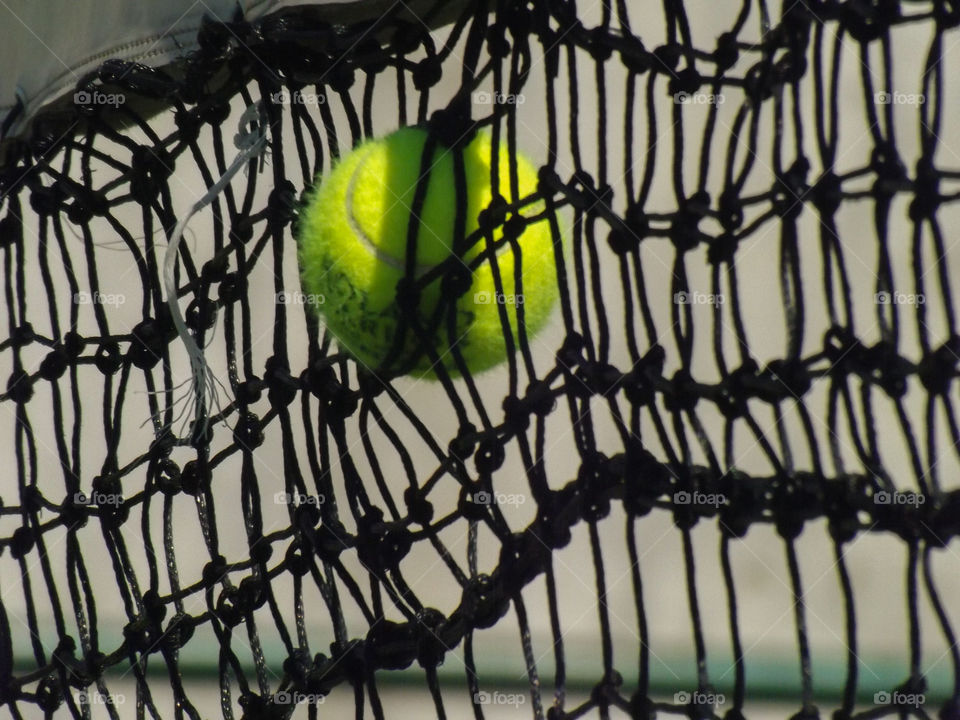 Close-up of tennis ball in net