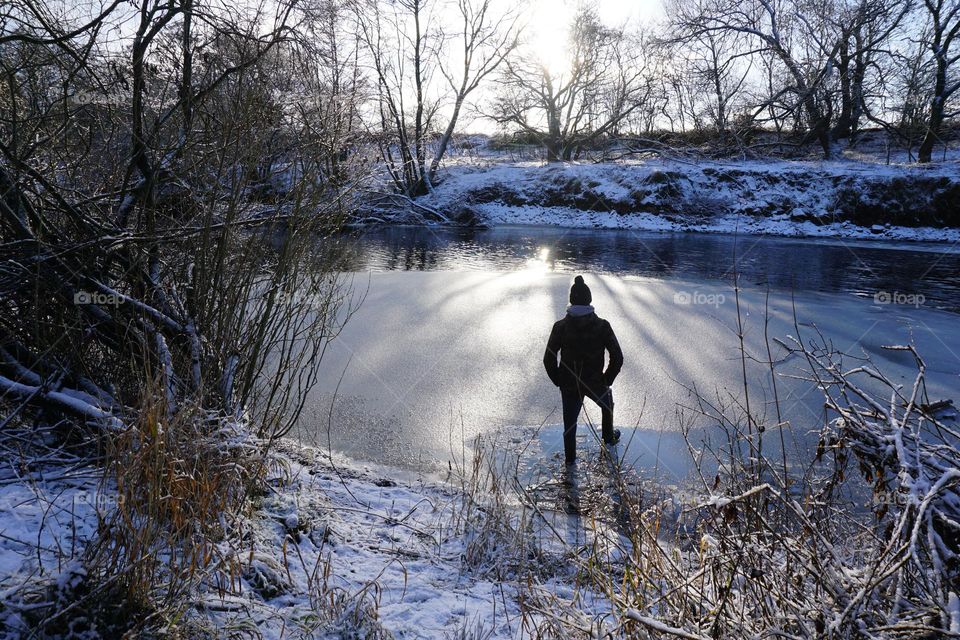 A thin layer of ice covers the river … 