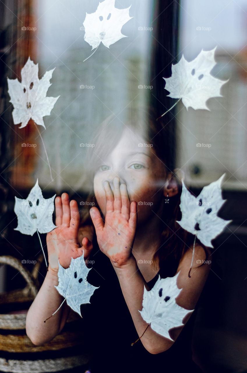 The girl looks out the window with ghosts.