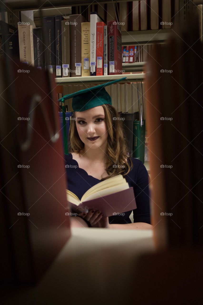 Woman in mortarboard standing at library