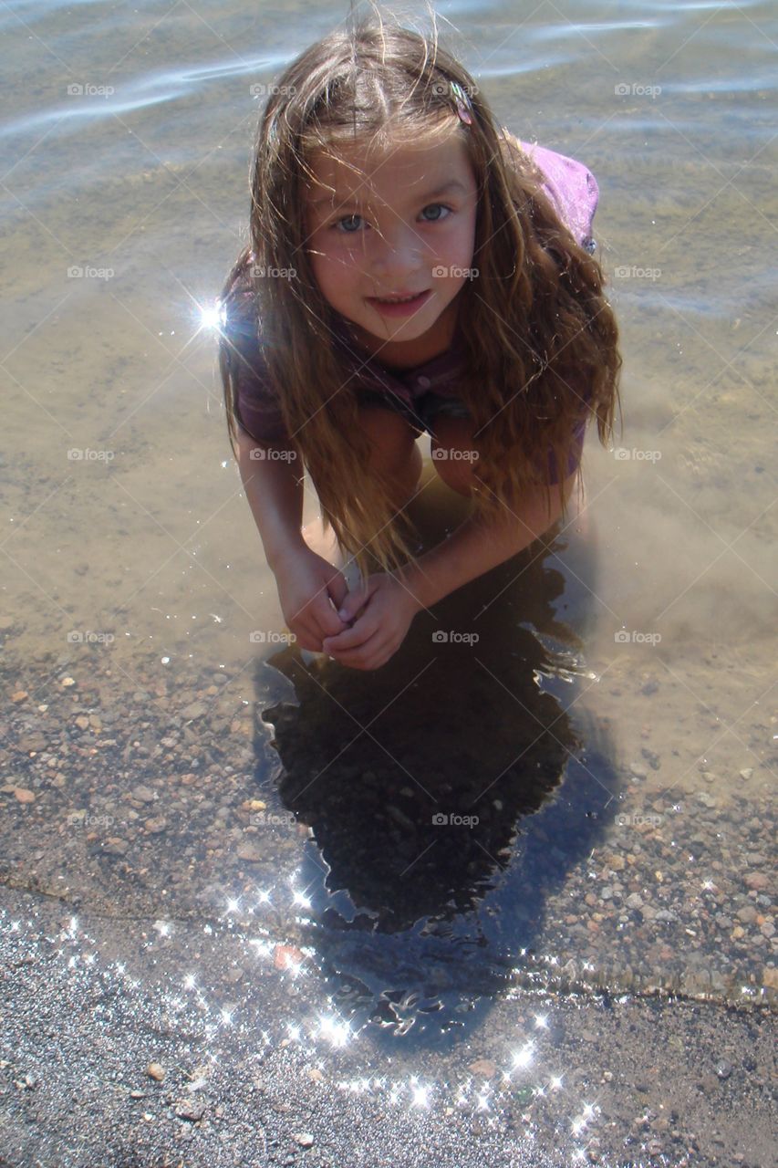 Portrait of cute girl crouching at beach