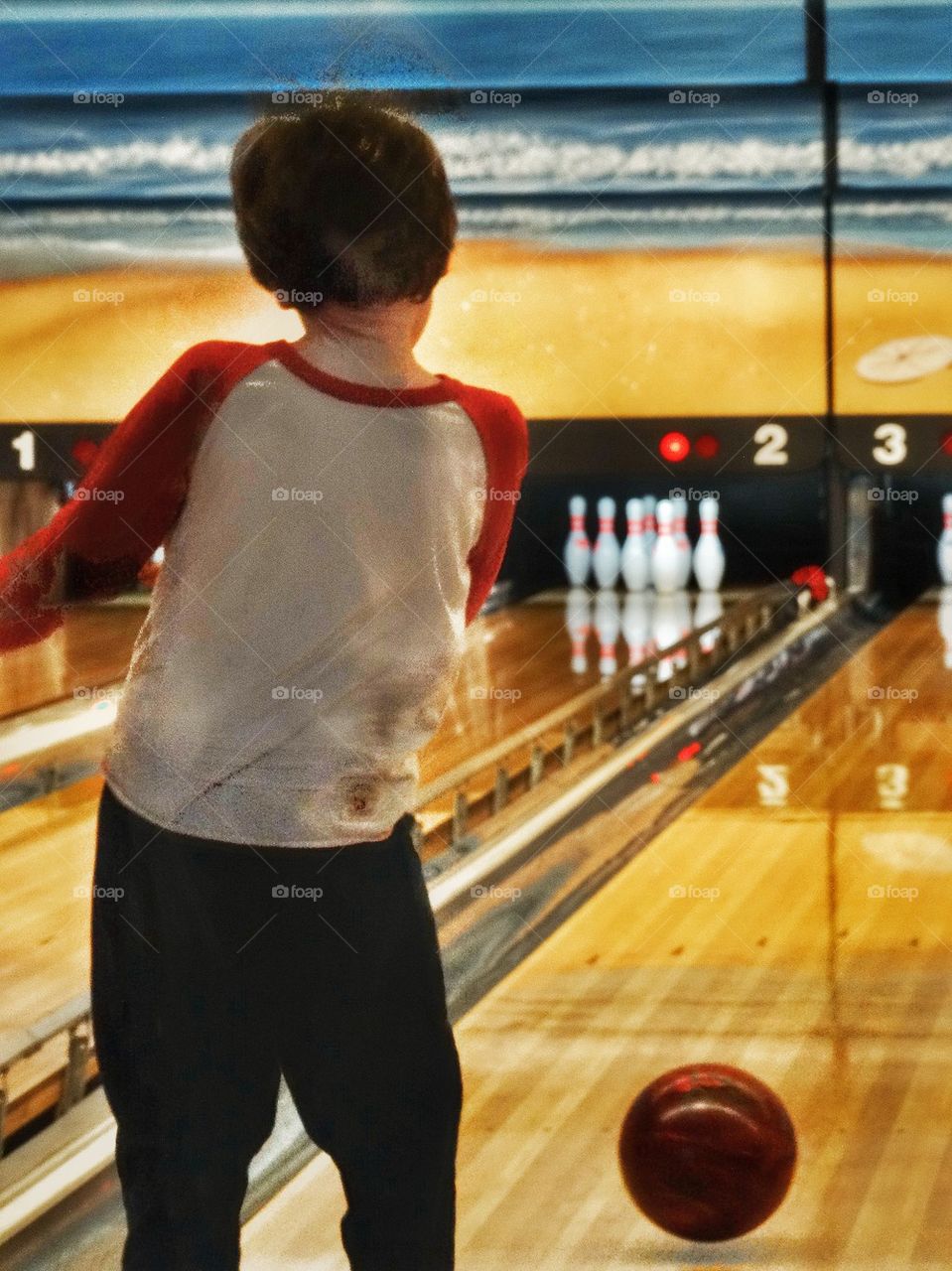 Young Boy Throwing A Bowling Ball. Child At The Bowling Alley