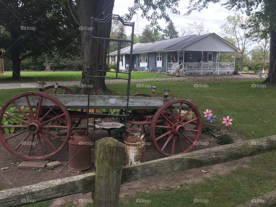 Farmhouse with old wagon and wheels.