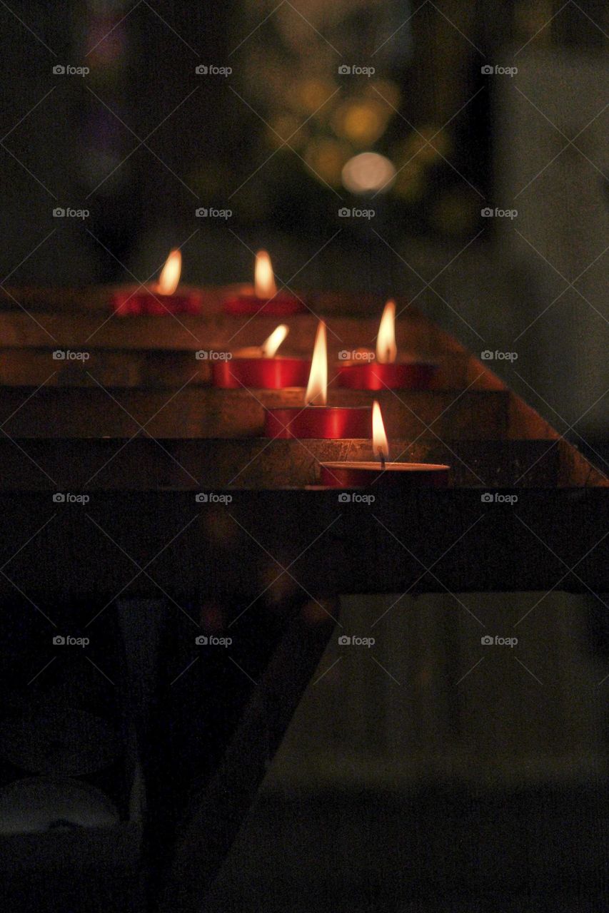 Candles lit against a black background. The luminous flames take center stage, and their soft, flickering light creates a serene ambiance that invites moments of contemplation