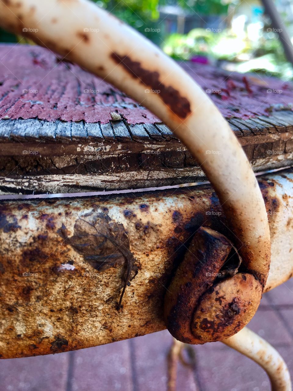 Back of rusted outdoor chair with weathered wood seat