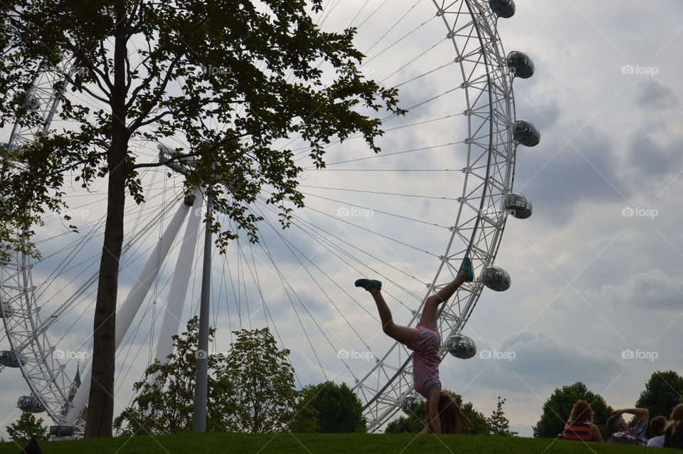 Ferris wheel and little girl making the wheel