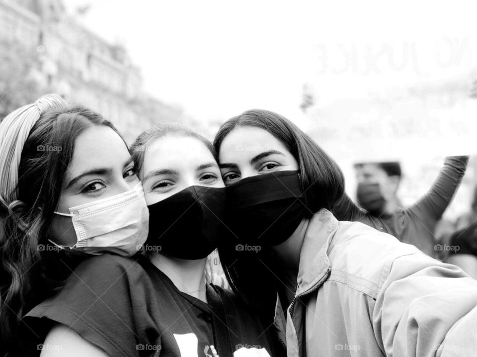 Three young girls wearing black/white masks