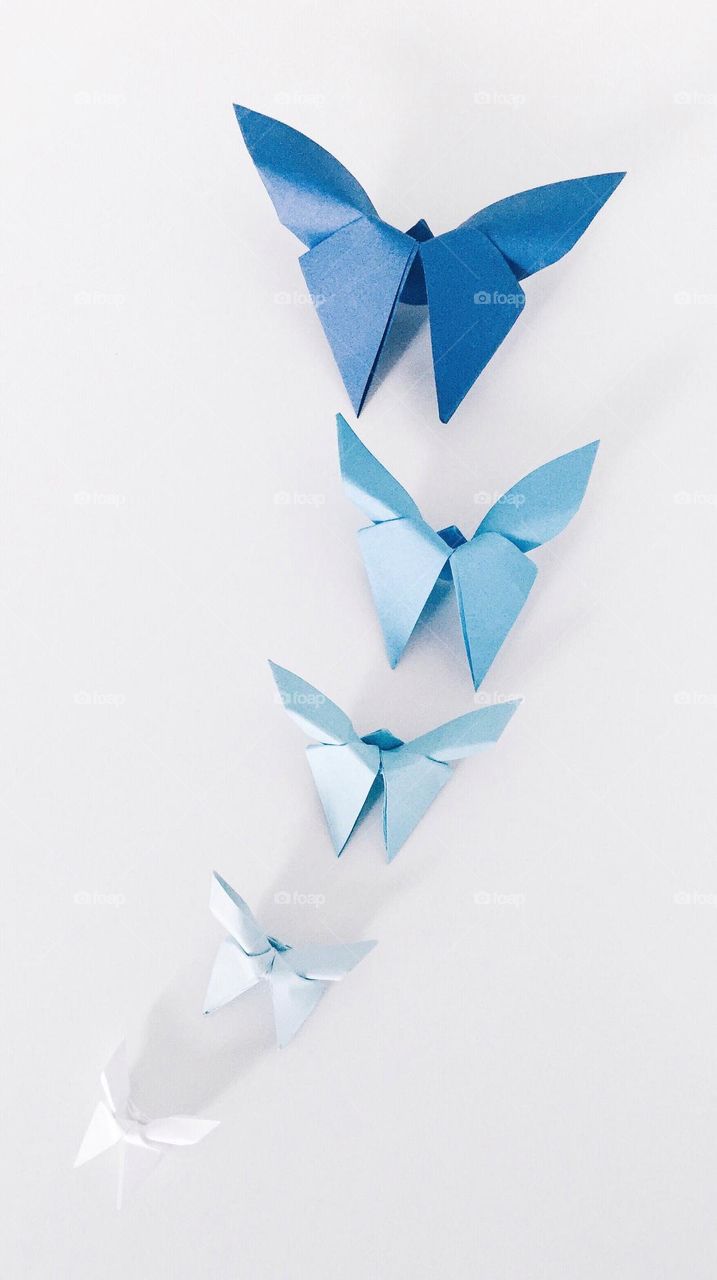 Overhead of differently colored origami paper butterflies