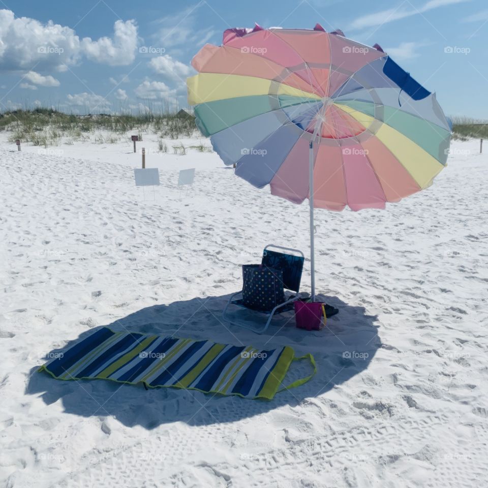 Beach umbrella white sand sky grassy dune blanket
