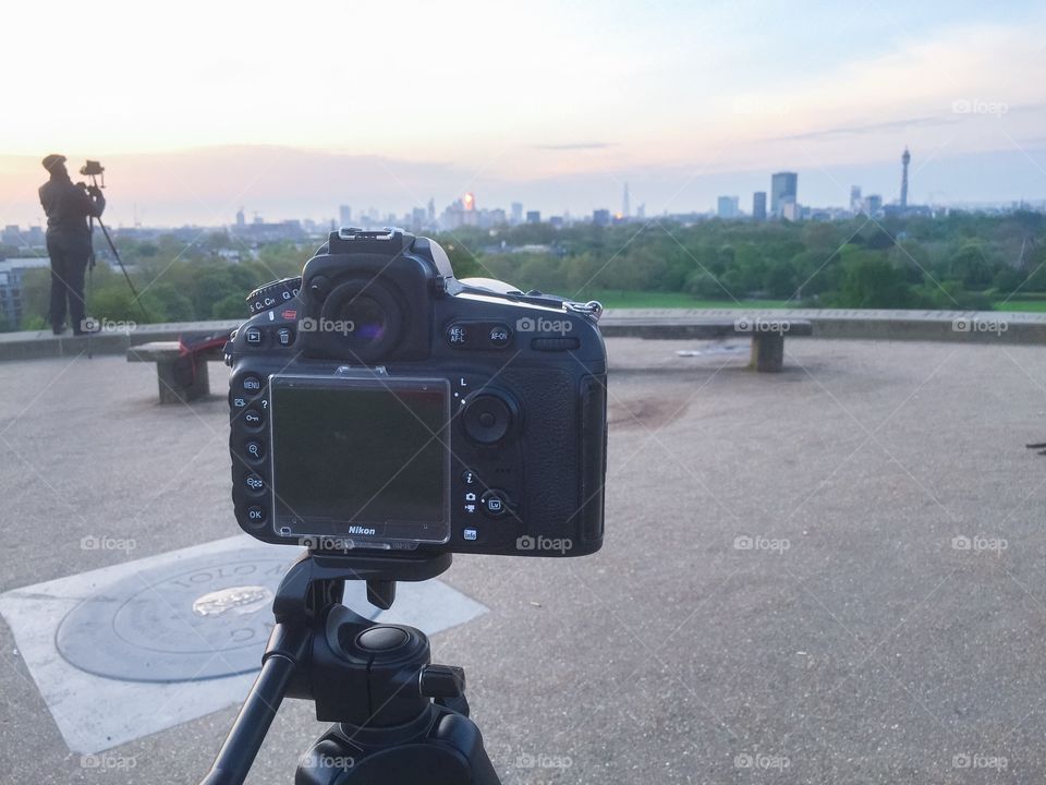 Camera taking pictures of London skyline at primerose hill in London.