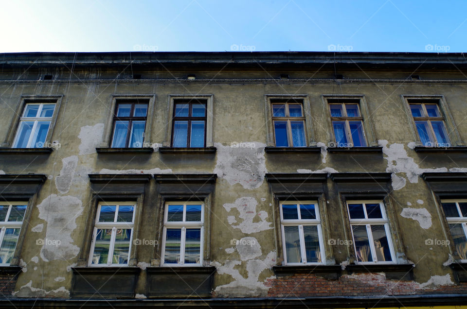 Low angle view of building exterior with windows in Kraków, Poland.