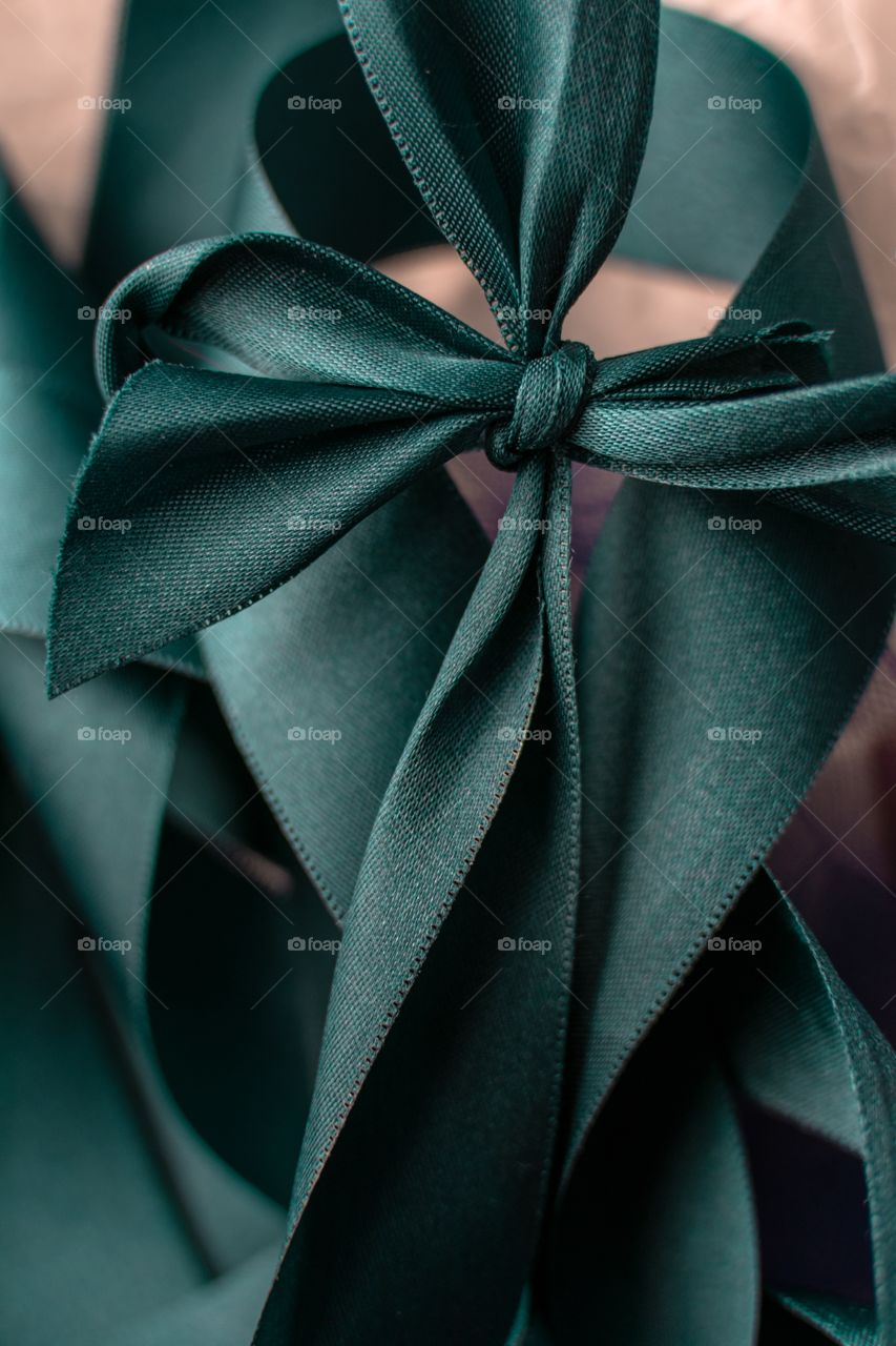 Teal satin ribbon in close up tied in a bow