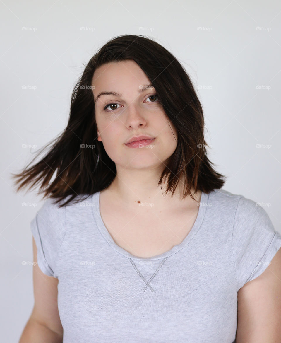 Young model in a gray shirt looking intense.