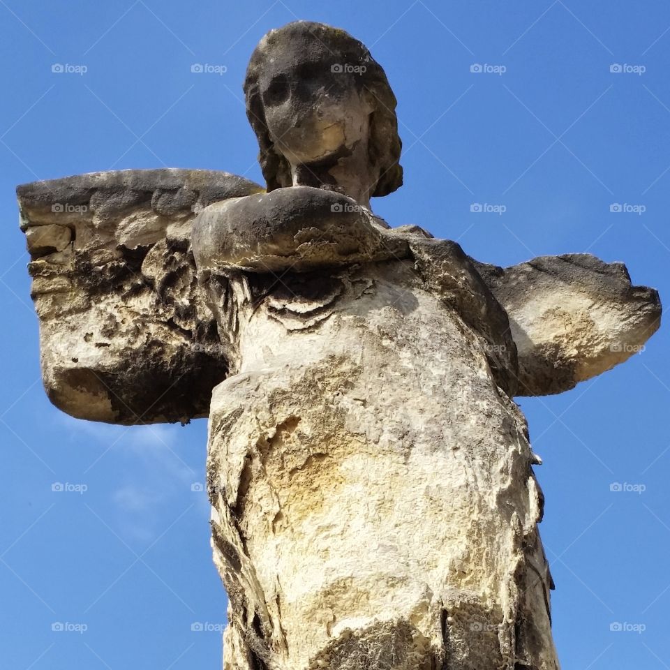 weathered angle statue on graveyard, France