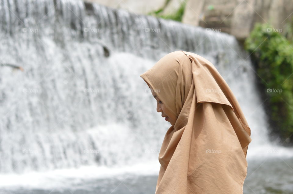 Girl beside waterfall