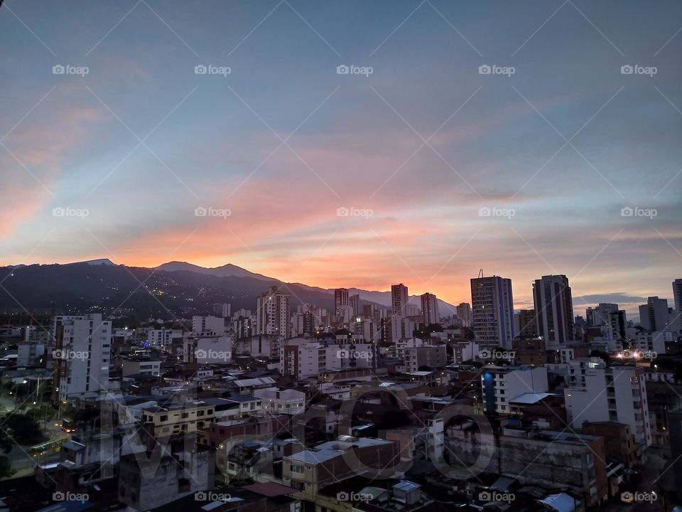 Hermoso paisaje del amanecer. El sol dando luz y color a la ciudad con sus montañas.