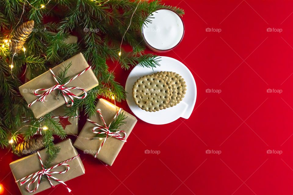 Christmas food composition on a red background, milk cookies for Santa and craft gifts