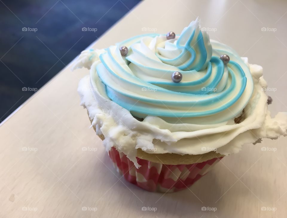 Beautiful blue and white swirl cupcake with silver sprinkles 