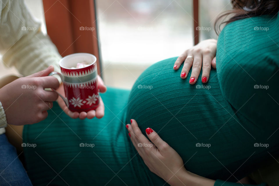 Pregnant woman with man holding cup