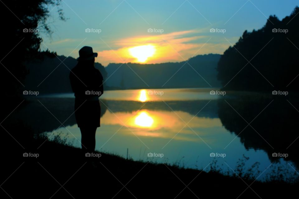 People standing and watching the sunrise in the morning amidst beautiful and refreshing nature.  Silhouette and sunrise. Beauty in nature.