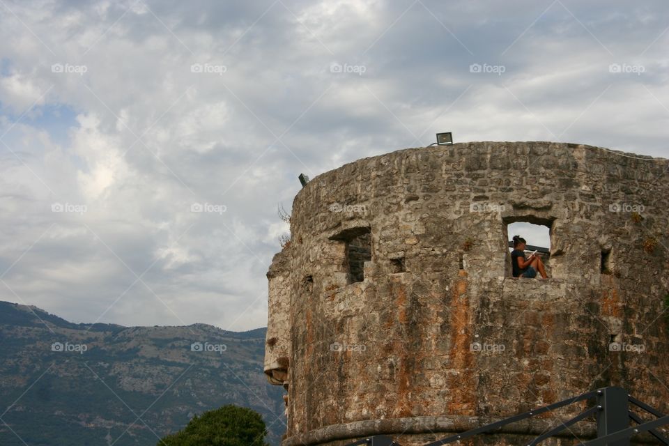 Girl reading a book in a medieval tower