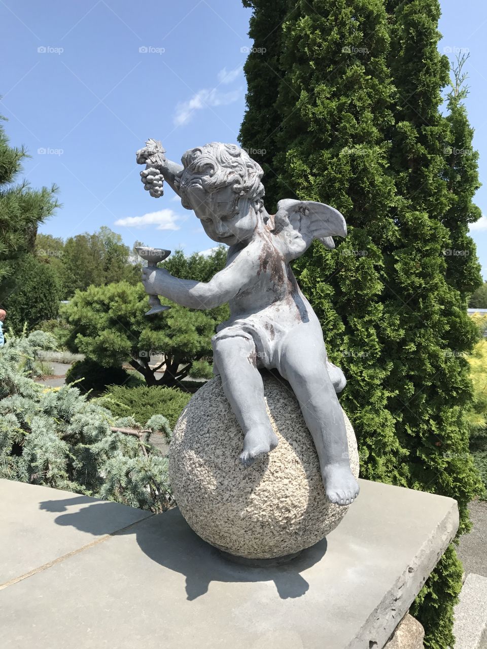 Cherub turning grapes in to wine