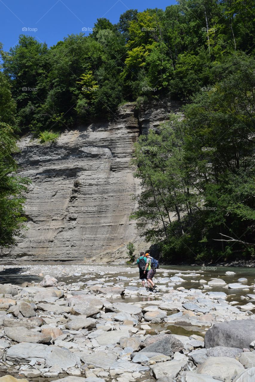 Hikers on rock in stream