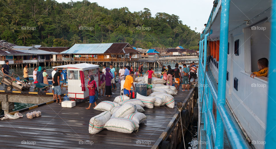 People selling and transporting goods at a small harbor on Sulawesi, Indonesia 