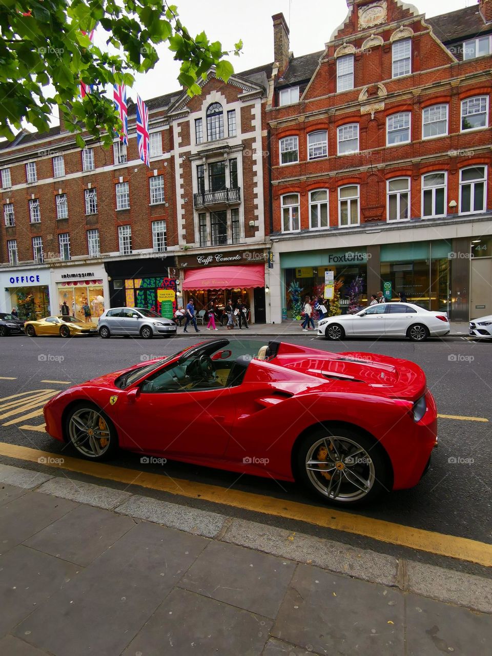 Red Ferrari. Expensive brands of cars are parked on the streets of London.