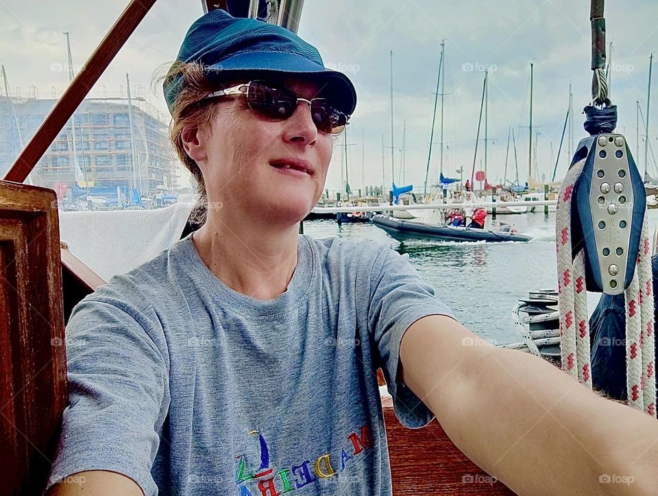 This lady is on a boat in „Warnemünde“, a small town near the city of „Rostock“ by the „Baltic Sea“, the „Ostsee” as the locals call it. She has been taking the steering wheel under supervision for part of her journey. 2023. Hypnotic Productions