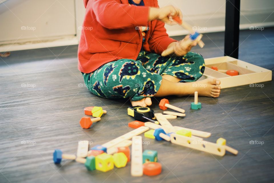 Kid learning use of screws and bolts practically using wooden samples and trying to make creative structures using the same. Learning and fun both at same time 