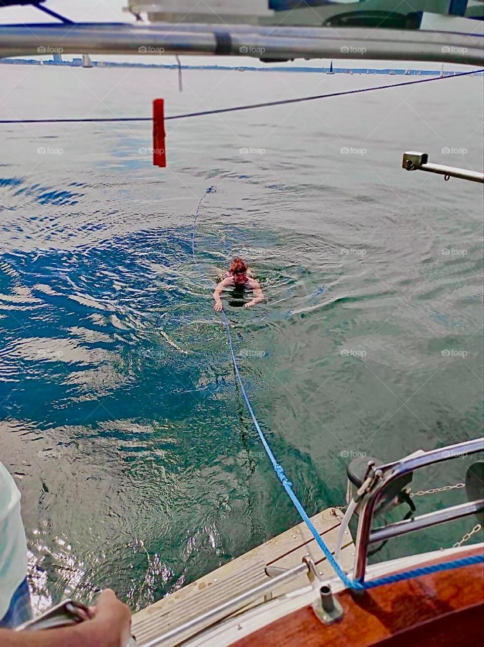 Swimming in the refreshing waters of the „Ostsee“, the „Baltic Sea“ can be a wonderful experience on a hot summer day in August 2023. Here it is done directly off the boat. The swimmer stays connected by holding on to a rope. Hypnotic Productions