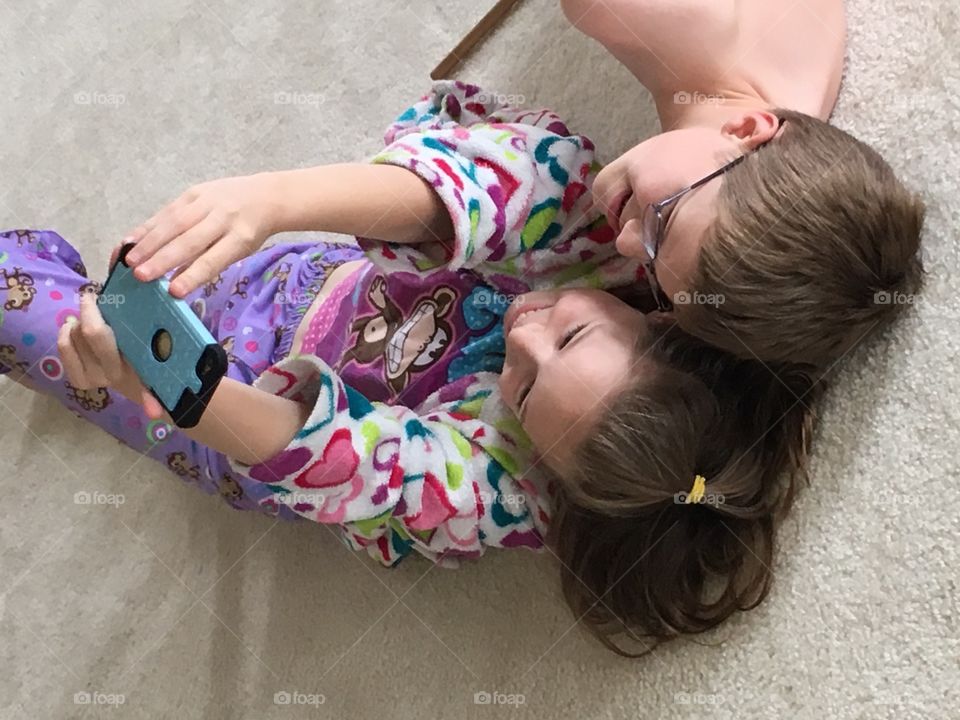 Sister and brother taking selfie with mobile phone