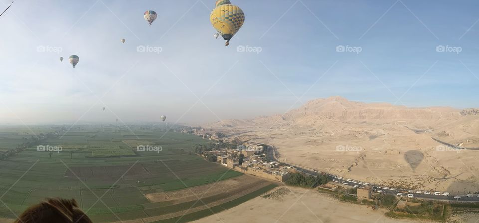 Hot-air balloons traversing the sky above Luxor, Egypt