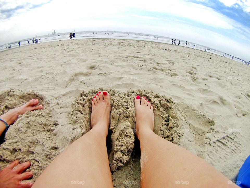 feet in sand at the beach