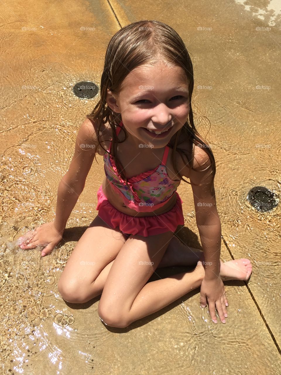 Little girl playing in water on a hot day