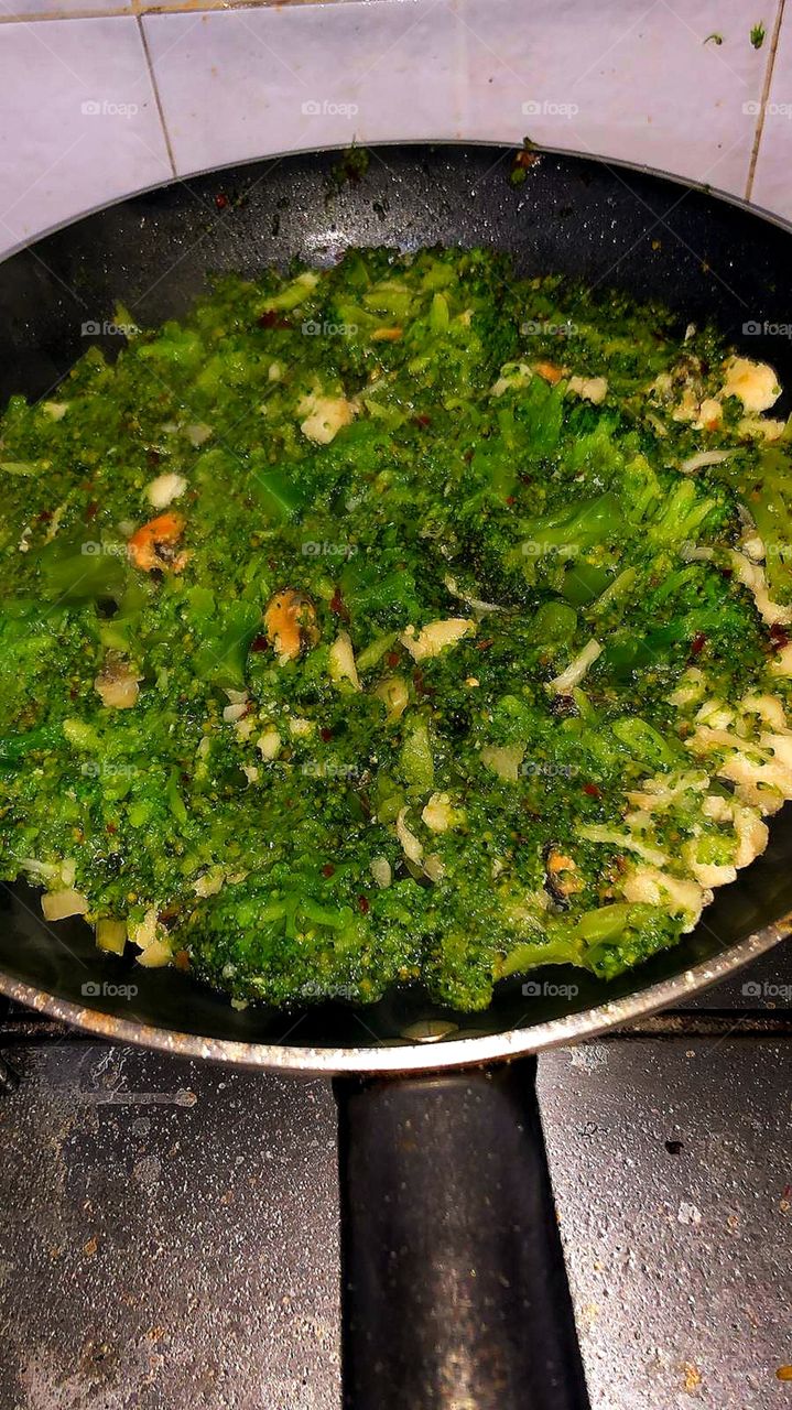 Cooking process.  Seafood with green vegetables