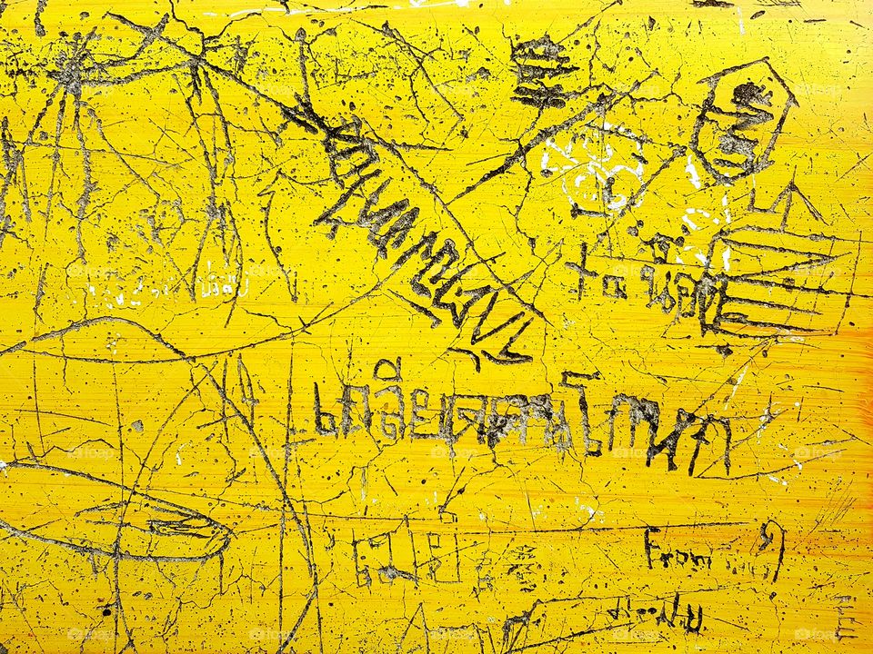 foreign language messy writing Thai letter on yellow background table top