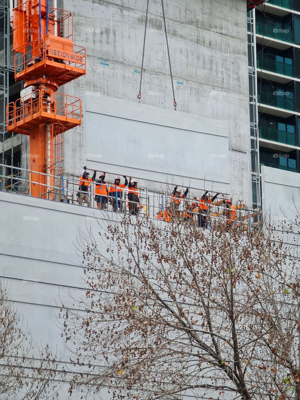 Workers placing building side walls on Melbourne Aspire Skyscraper